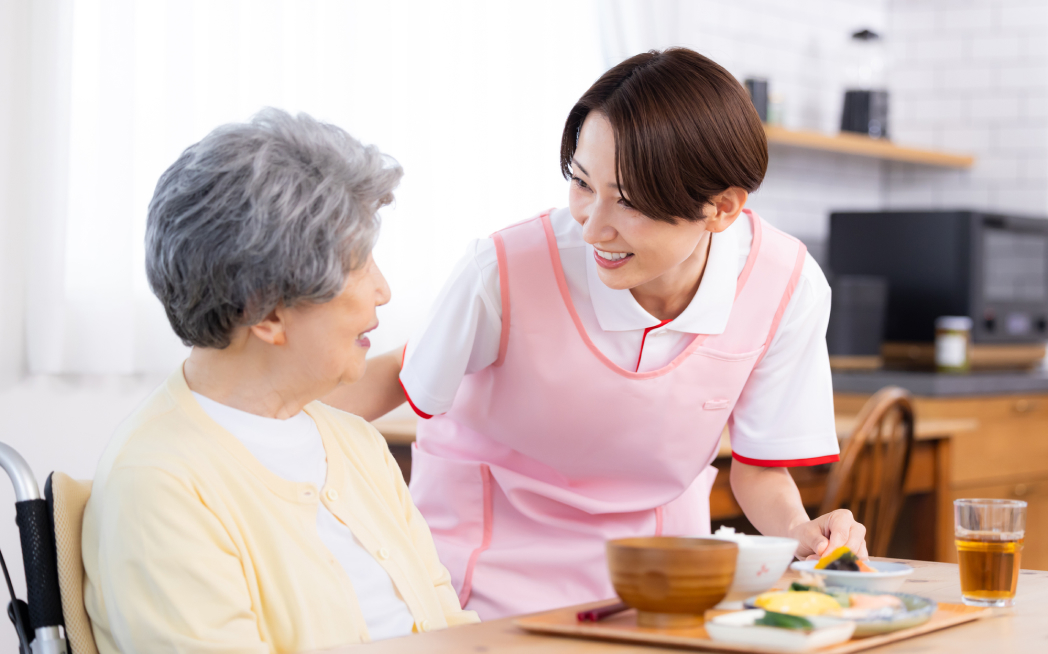 食事の介助　介護士と老人